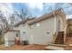 Backyard view of a two-story white brick home featuring a basement entrance and a wooden staircase at 1963 Shannon Ridge Ct, Decatur, GA 30032