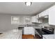 Well-lit kitchen featuring stone counters, modern appliances, and white cabinets at 1963 Shannon Ridge Ct, Decatur, GA 30032