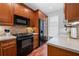 Modern kitchen with black appliances and wood cabinets at 3101 Howell Mill Nw Rd # 206, Atlanta, GA 30327