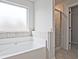 Bathroom with soaking tub, shower, and tiled walls at 11821 Rizvan Pl, Covington, GA 30014