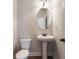 Small powder room with pedestal sink and oval mirror at 11821 Rizvan Pl, Covington, GA 30014