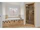 Spa-like bathroom with soaking tub, walk-in shower, and stained glass window at 2832 Springbluff Ln, Buford, GA 30519