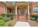 Brick front porch with columns, stone accents, and a wooden door at 2832 Springbluff Ln, Buford, GA 30519