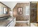 Elegant bathroom with brick accent wall, granite countertop, and stylish fixtures creates a unique and inviting space at 4874 Kettle River Pt, Suwanee, GA 30024