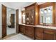 Bathroom with double vanity, wood cabinets, and marble countertops at 4874 Kettle River Pt, Suwanee, GA 30024