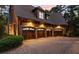 Three car garage with arched doorways and brick exterior providing ample space for vehicles and storage at 4874 Kettle River Pt, Suwanee, GA 30024