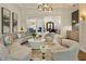 Elegant living room showcasing a curved sofa, modern lighting, and open access to other living spaces at 4874 Kettle River Pt, Suwanee, GA 30024