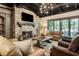 Inviting living room with stone fireplace, wood beams, chandelier, and plenty of seating for relaxation and entertainment at 4874 Kettle River Pt, Suwanee, GA 30024