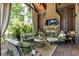 Covered outdoor living space featuring a fireplace, TV, and comfortable seating at 4874 Kettle River Pt, Suwanee, GA 30024