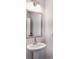Small bathroom with pedestal sink and framed mirror at 2709 Richmond Row Dr, Suwanee, GA 30024