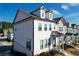 Side view of a two-story townhome showcasing white siding and a partially visible gray neighbor at 2709 Richmond Row Dr, Suwanee, GA 30024
