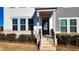 Front entryway with brick steps, black door, and mature shrubs at 2709 Richmond Row Dr, Suwanee, GA 30024