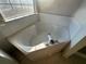 Close-up view of a corner bathtub in a bathroom at 4010 Peachtree Farms Rd, Rex, GA 30273