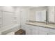 Bathroom with granite double sink vanity and bath/shower combo at 11831 Rizvan Pl, Covington, GA 30014