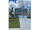 Charming two-story home with a well-manicured lawn, two-car garage, and classic architectural details at 11831 Rizvan Pl, Covington, GA 30014