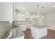Contemporary kitchen with white cabinets, granite countertops, tile backsplash, stainless sink, pendant lights, and a kitchen island at 11831 Rizvan Pl, Covington, GA 30014