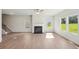 Large living room featuring hardwood floors, multiple windows, and a classic fireplace at 11831 Rizvan Pl, Covington, GA 30014