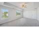 Bright main bedroom features large windows, carpet, and a ceiling fan at 11831 Rizvan Pl, Covington, GA 30014