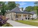 Charming stone home featuring a welcoming front porch, gray roof, and well-manicured front yard and walkway at 199 Racine Sw St, Atlanta, GA 30314