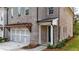 Beautiful brick townhome highlighting a two-car garage and covered entrance with manicured landscaping at 502 Winston Croft Cir # 53, Johns Creek, GA 30022