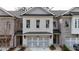 Charming brick townhome featuring a two-car garage, covered entryway, and neatly landscaped front yard at 502 Winston Croft Cir # 53, Johns Creek, GA 30022