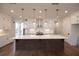 A modern kitchen featuring a spacious center island, white cabinets, and designer globe pendant lights at 502 Winston Croft Cir # 53, Johns Creek, GA 30022