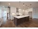 A kitchen featuring a large island, modern appliances, white cabinets, and hardwood floors at 502 Winston Croft Cir # 53, Johns Creek, GA 30022