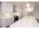 Kitchen featuring a large island with quartz countertops, stylish lighting, and stainless steel appliances at 502 Winston Croft Cir # 53, Johns Creek, GA 30022
