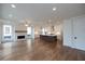 Spacious living room featuring hardwood floors, stone fireplace, and open layout to the kitchen and a large island at 502 Winston Croft Cir # 53, Johns Creek, GA 30022