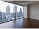 Bedroom with hardwood floors and floor-to-ceiling windows offering stunning city skyline views at 1080 Peachtree Ne St # 2716, Atlanta, GA 30309