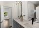 Modern bathroom with dual vanity, gray cabinets, and arched mirror at 1432 Mims Sw St, Atlanta, GA 30314
