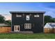 Rear exterior view of the home highlighting dark siding, bright windows, and a quaint back porch area at 1432 Mims Sw St, Atlanta, GA 30314
