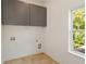 Laundry room with gray cabinets and tile floor at 1432 Mims Sw St, Atlanta, GA 30314