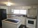 White kitchen with black appliances and an island at 2455 Lake Harbin Rd, Morrow, GA 30260