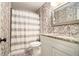 Cozy bathroom with shower-tub combo, granite vanity and decorative wallpaper at 1514 Howell Highlands Dr, Stone Mountain, GA 30087