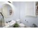 Powder room with pedestal sink, oval mirror, and light blue walls at 1399 Knob Hill Se Ct, Atlanta, GA 30316