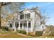 Charming two-story white home featuring a welcoming front porch, black shutters and professionally landscaped yard at 1399 Knob Hill Se Ct, Atlanta, GA 30316