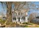 Two-story white house with a wraparound porch and landscaping. Large tree in the front yard at 1399 Knob Hill Se Ct, Atlanta, GA 30316