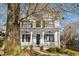 Charming two-story white home featuring a welcoming front porch with ceiling fans and professionally landscaped yard at 1399 Knob Hill Se Ct, Atlanta, GA 30316