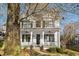 Two-story white house with a wraparound porch and landscaping. Large tree to the left of the house at 1399 Knob Hill Se Ct, Atlanta, GA 30316