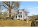 Two-story white house with a wraparound porch and landscaping. Side yard view at 1399 Knob Hill Se Ct, Atlanta, GA 30316