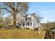 Spacious front yard with mature trees offering shade for a charming two-story home with inviting front porch at 1399 Knob Hill Se Ct, Atlanta, GA 30316