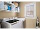 Well-lit laundry room with modern appliances and shelving for storage at 1399 Knob Hill Se Ct, Atlanta, GA 30316