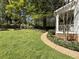 Landscaped side yard with stone walkway, lush greenery and blooming azaleas leading to the charming two-story home at 1399 Knob Hill Se Ct, Atlanta, GA 30316