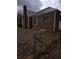 Side view of brick house with a metal roof and windows with bars, fenced-in yard with leaves at 1643 Westhaven Sw Dr, Atlanta, GA 30311