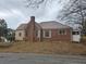 Exterior shot of home with brick, chimney, metal roof, shutters, and enclosed sunroom at 1643 Westhaven Sw Dr, Atlanta, GA 30311