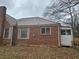 A side view of a brick house with metal roof, shutters, and windows with bars at 1643 Westhaven Sw Dr, Atlanta, GA 30311