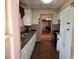 Galley kitchen with wood floor, white cabinets, and a view into the dining room at 1643 Westhaven Sw Dr, Atlanta, GA 30311