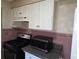 The kitchen features appliances, white cabinets, and vintage backsplash with pink trim at 1643 Westhaven Sw Dr, Atlanta, GA 30311