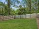 Large backyard with a wooden fence and mature trees at 775 Stickley Oak Way, Woodstock, GA 30189